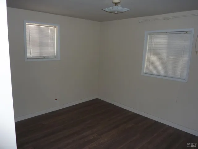 an empty room with wooden floor and closet