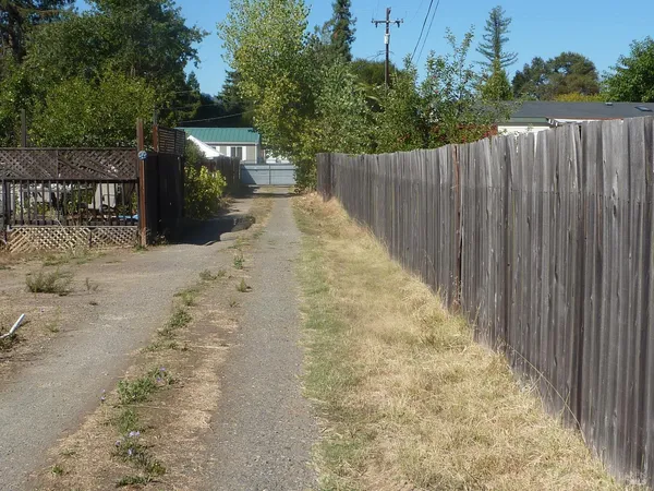 a view of a backyard with wooden fence