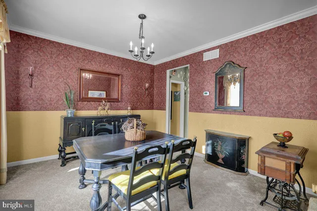 a view of a dining room with furniture and a chandelier
