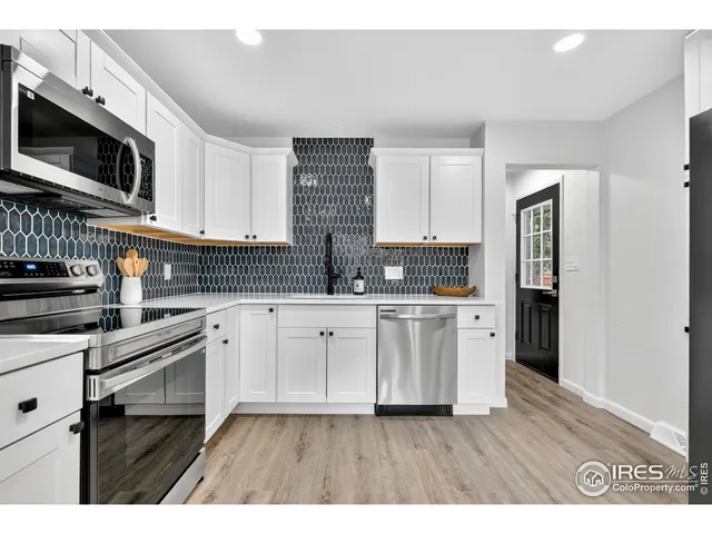 a kitchen with granite countertop a stove top oven and cabinets