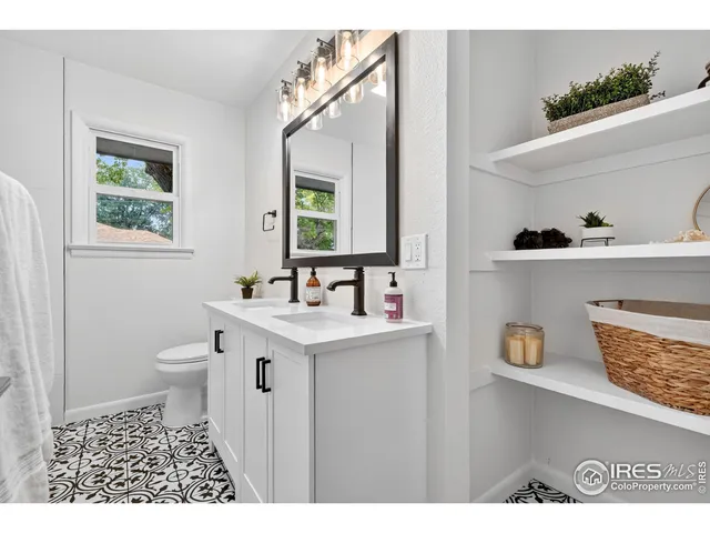 a bathroom with a sink a mirror a vanity and a shower