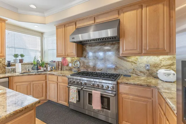 a kitchen with granite countertop a stove and cabinets