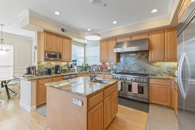 a kitchen with stainless steel appliances granite countertop a sink stove and refrigerator