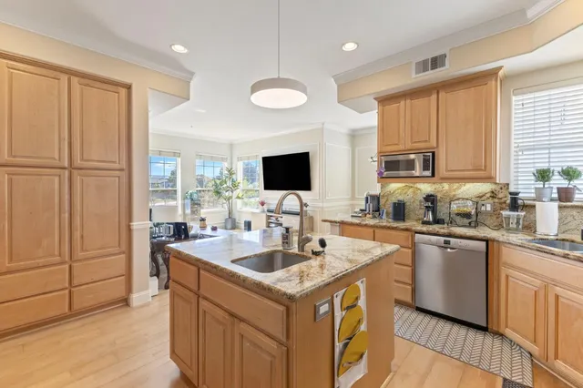 a kitchen with stainless steel appliances granite countertop a sink stove and refrigerator