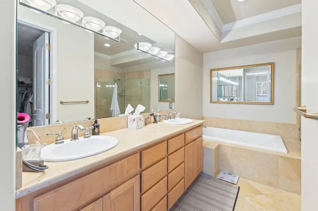 a bathroom with a granite countertop sink mirror and a bath tub