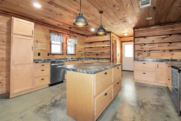 a kitchen with granite countertop a sink window and refrigerator