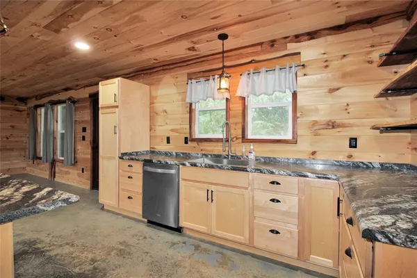 a kitchen with granite countertop a sink stainless steel appliances and cabinets