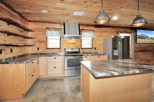 a kitchen with stainless steel appliances granite countertop a sink a stove and a wooden cabinets