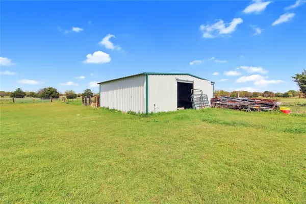 a view of a chair and table in backyard of the house