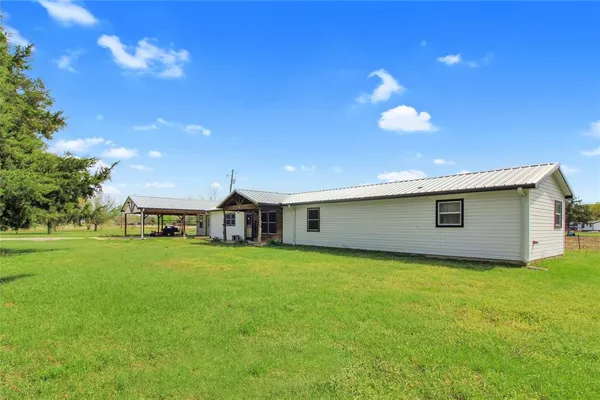 a front view of a house with yard and tree