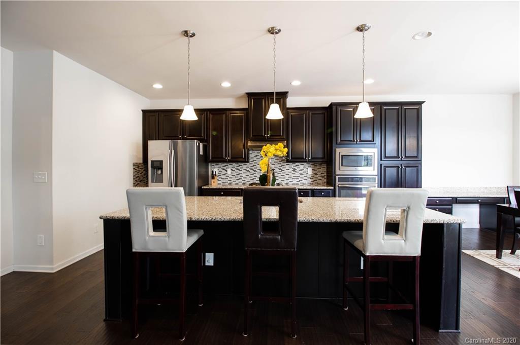 2279 Drake Mill Lane Southwest Concord, NC 28025 - Photo 14 of 40 a kitchen with a dining table chairs and white cabinets