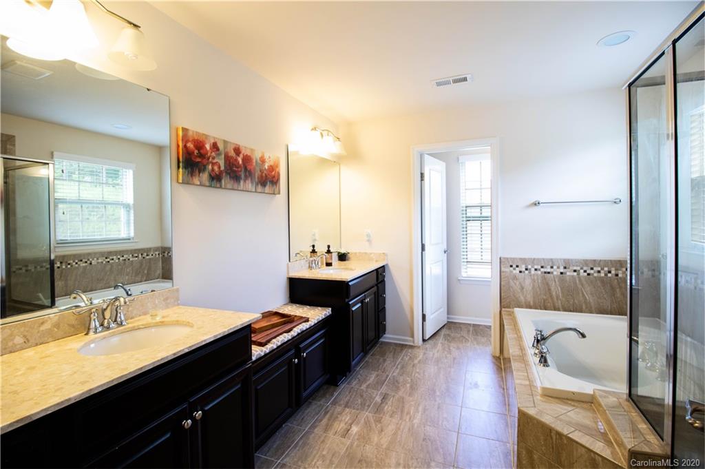 2279 Drake Mill Lane Southwest Concord, NC 28025 - Photo 26 of 40 a en suite bathroom with a granite countertop sink a toilet a mirror and shower