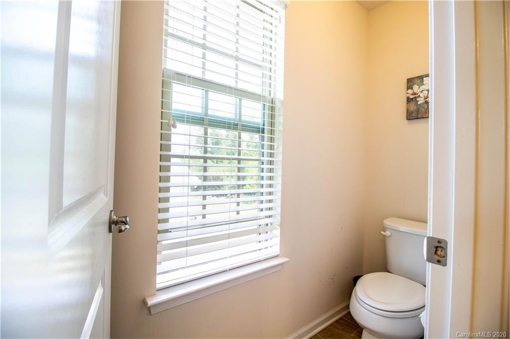 2279 Drake Mill Lane Southwest Concord, NC 28025 - Photo 28 of 40 a white toilet sitting next to a window in a bathroom