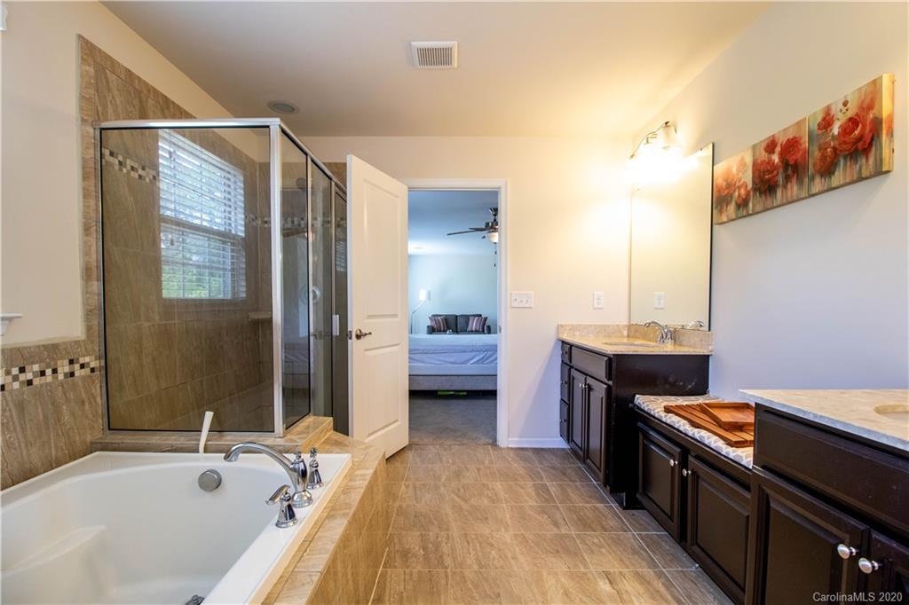 2279 Drake Mill Lane Southwest Concord, NC 28025 - Photo 29 of 40 a spacious bathroom with a tub sink and mirror