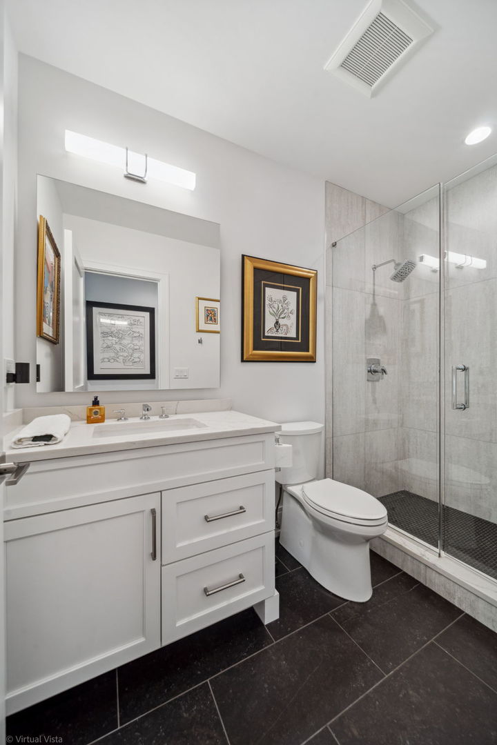 110 South Washington Street, Unit 400 Naperville, IL 60540 - Photo 25 of 34 a bathroom with a toilet sink double vanity and mirror