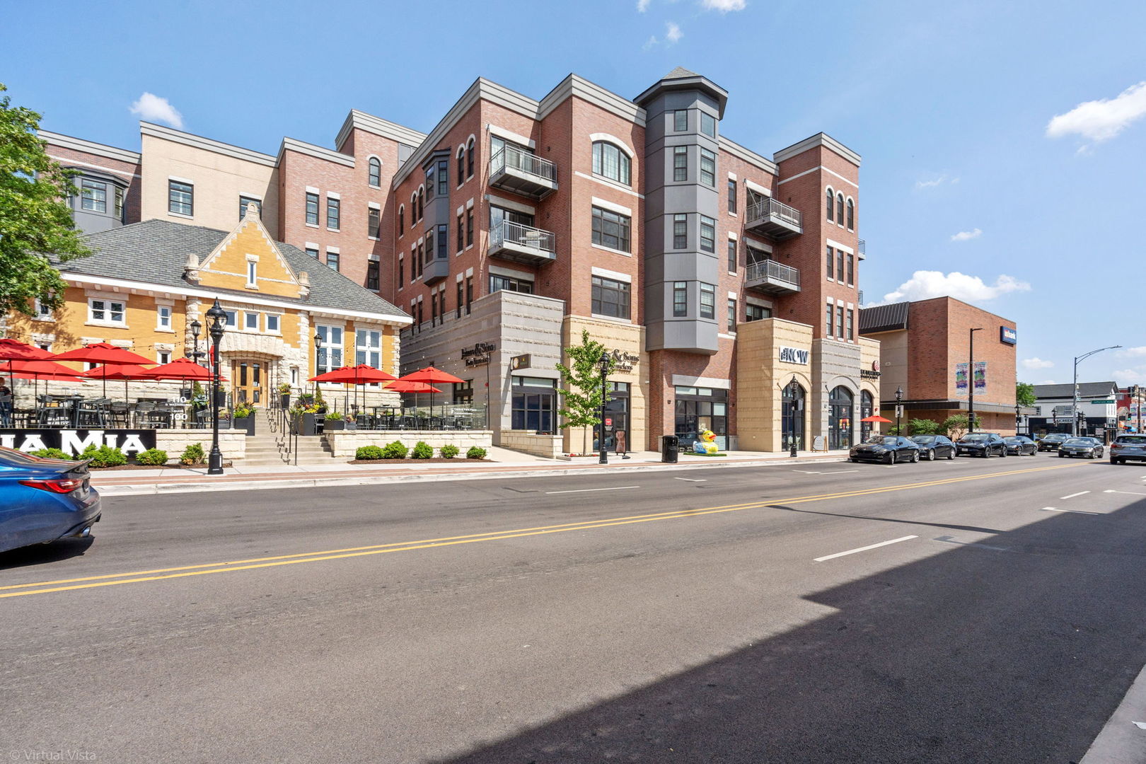 110 South Washington Street, Unit 400 Naperville, IL 60540 - Photo 32 of 34 a city street with tall buildings and a cars parked in front of it