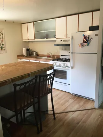 a kitchen with kitchen island a stove a sink and a refrigerator