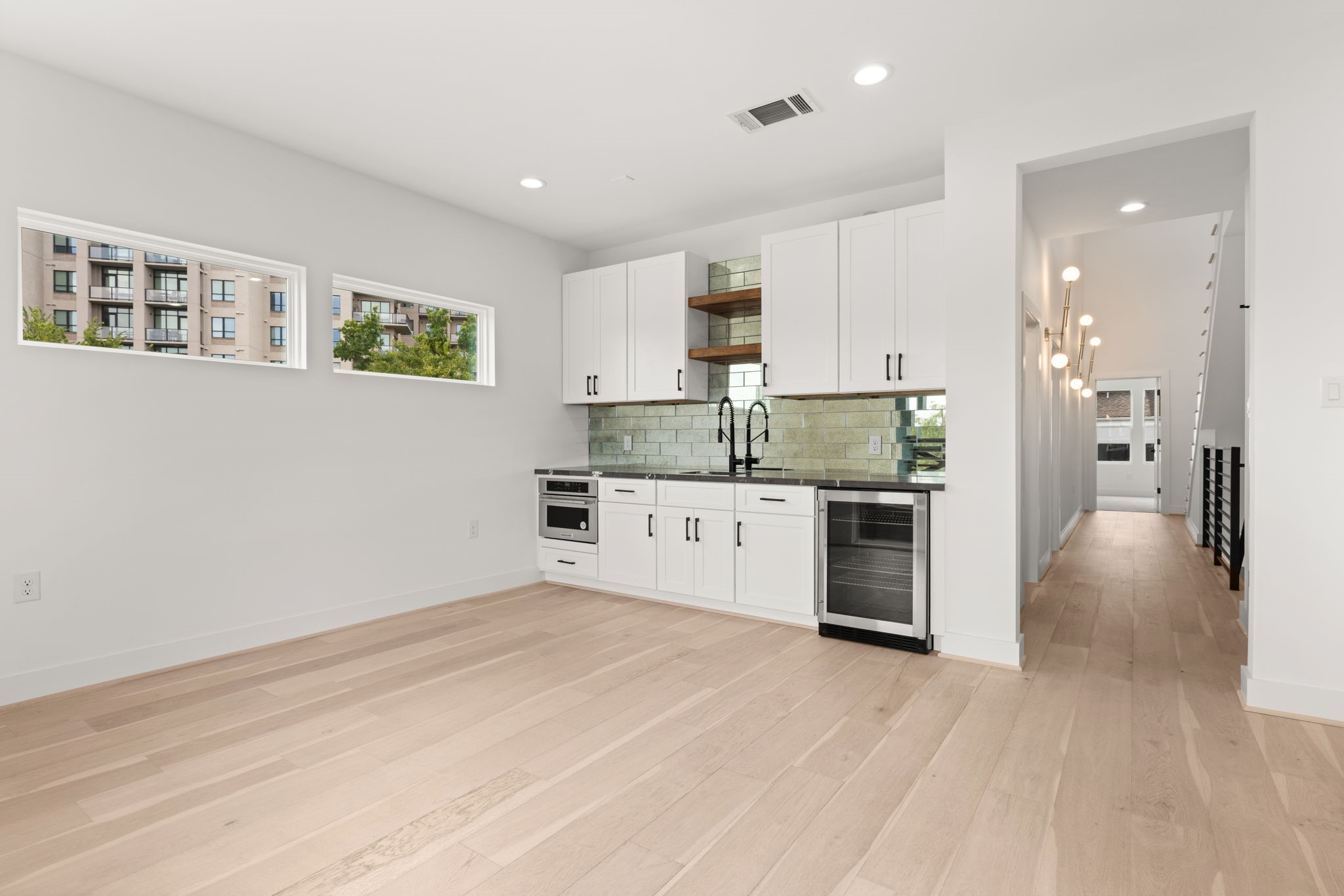 6209 Westcott Street Houston, TX 77007 - Photo 16 of 29 Third-floor bonus area with a sleek wet bar, beverage cooler, and open layout—perfect for entertaining or relaxing.