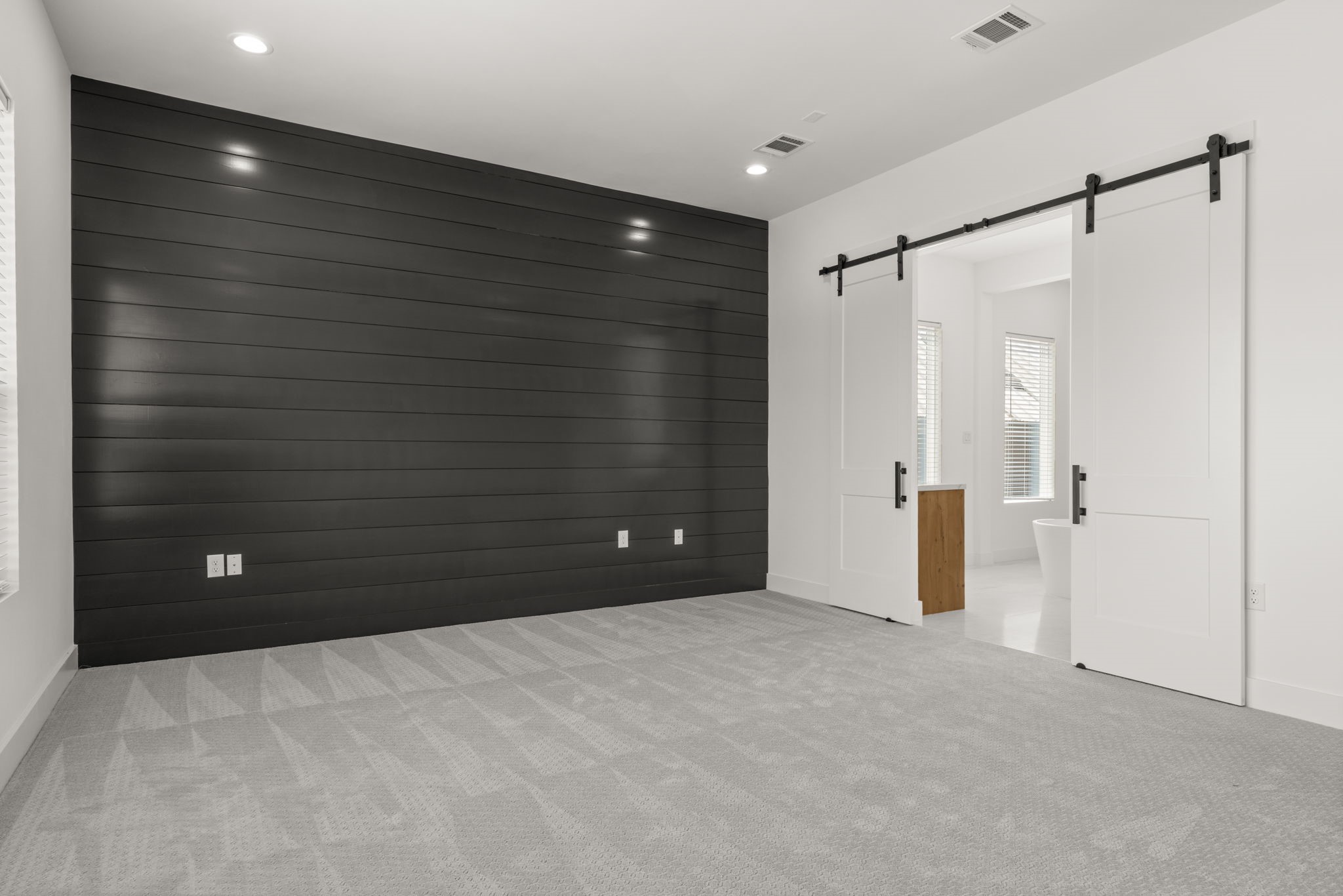 6209 Westcott Street Houston, TX 77007 - Photo 7 of 29 Luxurious primary suite featuring a dramatic custom accent wall, elegant barn doors, and seamless flow into a spa-inspired bath.