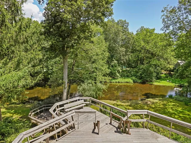 a view of a yard with a table and chairs under an umbrella
