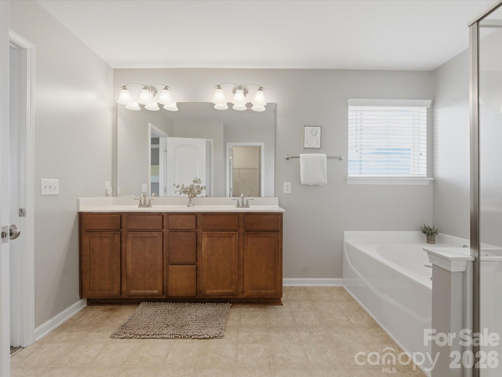 79321 Ridgehaven Road Lancaster, SC 29720 - Photo 22 of 35 a bathroom with a tub a double vanity sink and a mirror