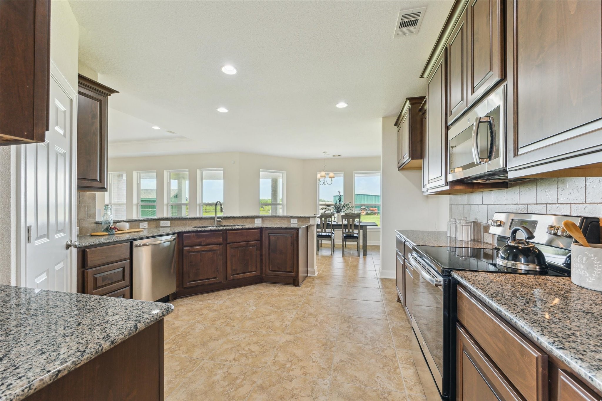 3850 Farm To Market 2917 Alvin, TX 77511 - Photo 10 of 30 a kitchen with stainless steel appliances granite countertop a sink stove and refrigerator