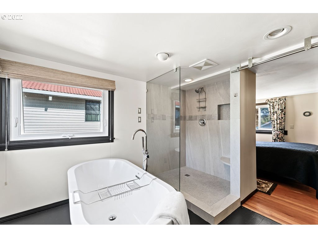 205 North Bridgeton Road, Unit W09 Portland, OR 97217 - Photo 26 of 32 a bathroom with a tub a sink and mirror