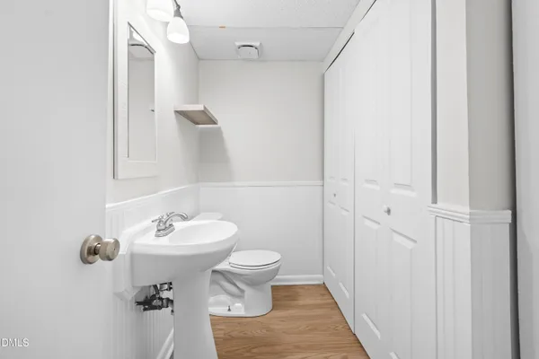 a view of an empty room with wooden floor fireplace and a window