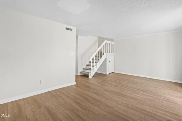 an empty room with wooden floor and fireplace