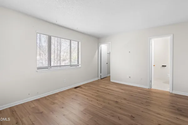 a view of an empty room with wooden floor