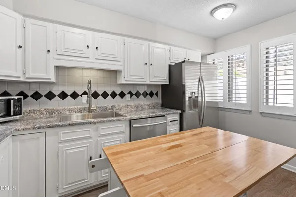 a kitchen with stainless steel appliances granite countertop a sink and cabinets