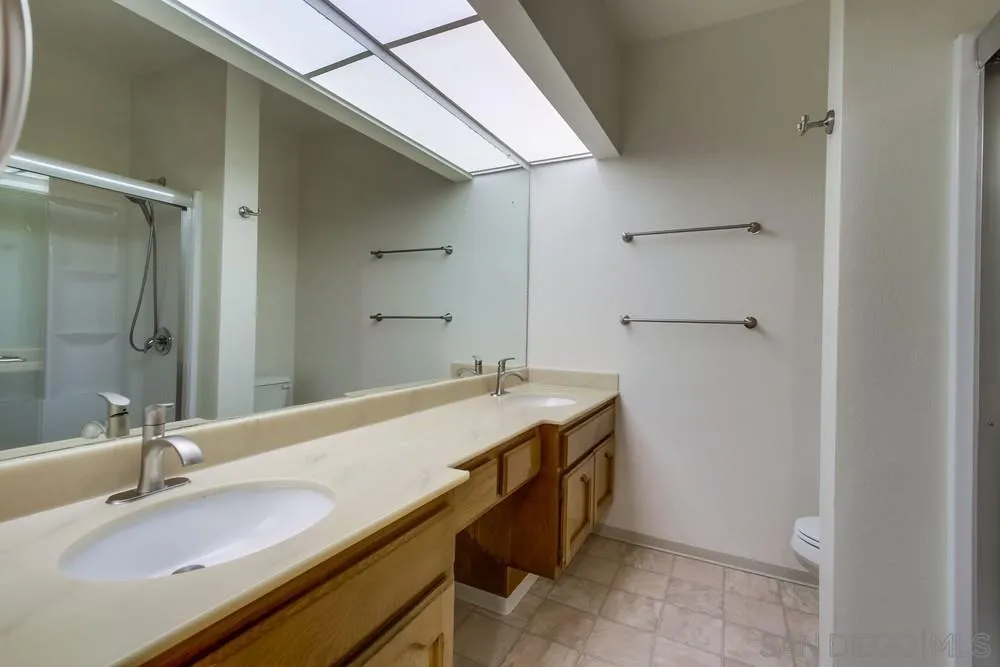 5865 Friars Road, Unit 3113 San Diego, CA 92110 - Photo 23 of 39 a bathroom with a granite countertop sink and a mirror