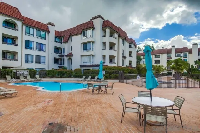 a view of a building with a yard and sitting area