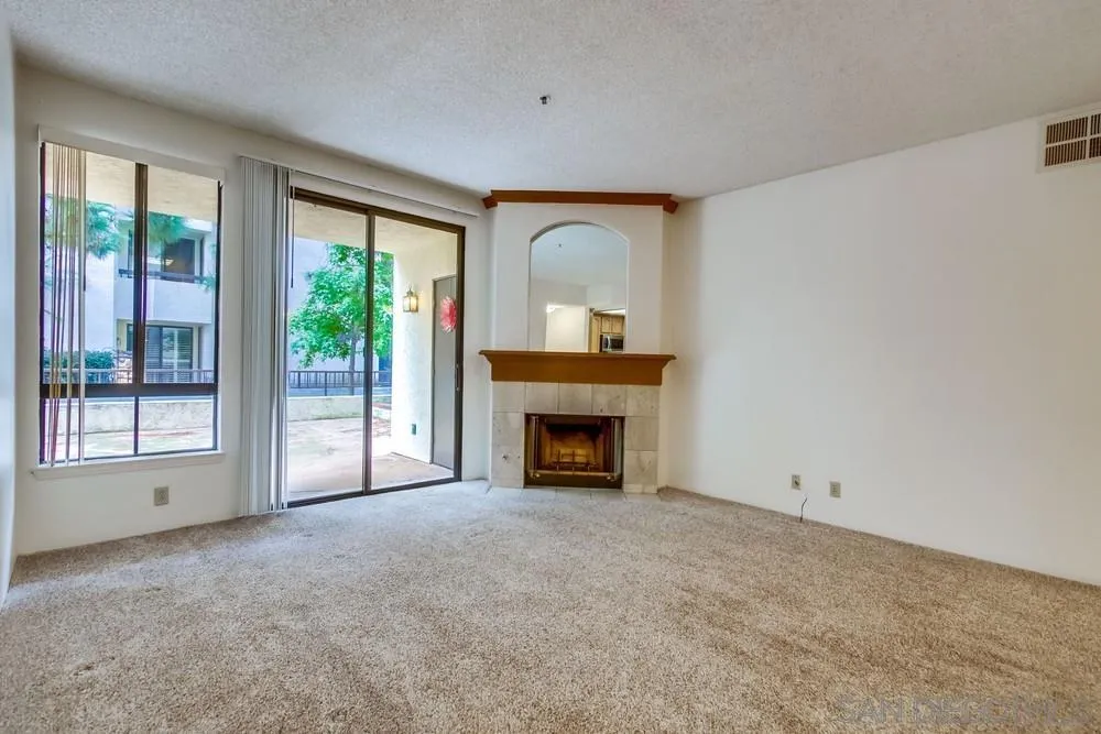 5865 Friars Road, Unit 3113 San Diego, CA 92110 - Photo 4 of 39 a view of an empty room with a fireplace and a window