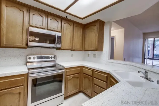 a kitchen with stainless steel appliances granite countertop a sink stove and microwave
