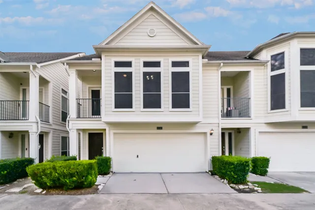 a front view of a brick house with a yard and plants