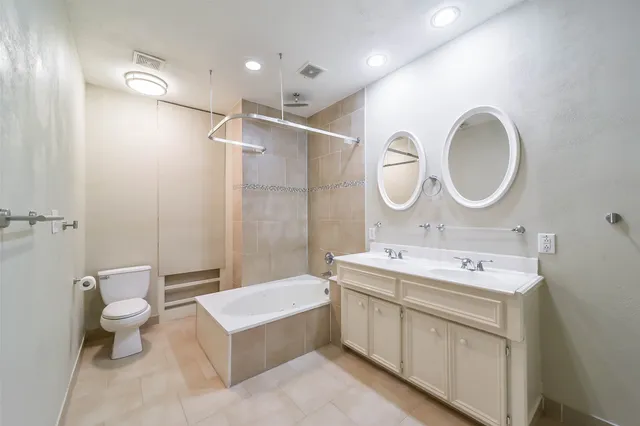 a spacious bathroom with a toilet sink and mirror