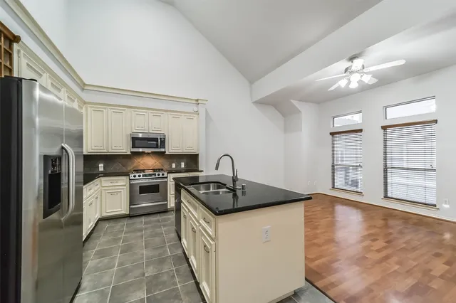 a kitchen with stainless steel appliances granite countertop a stove a sink dishwasher and a refrigerator