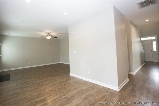 a view of empty room with wooden floor and window