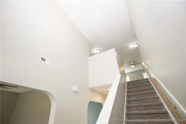 a view of a hallway with wooden floor and white walls