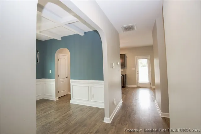 a view of an empty room with window and wooden floor