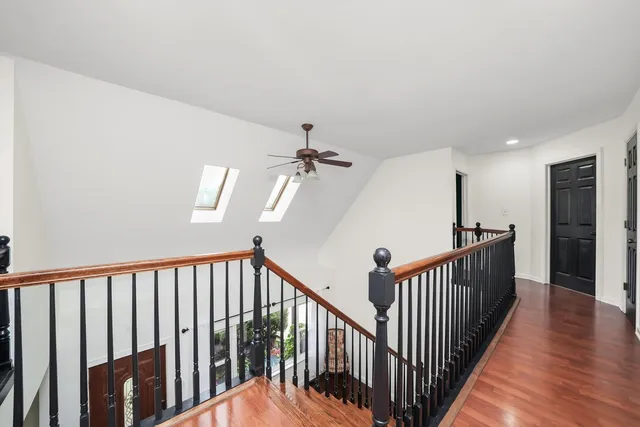 a view of a hallway with wooden floor and stairs