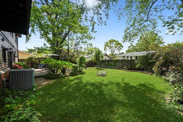 a view of a patio with table and chairs potted plants and large tree