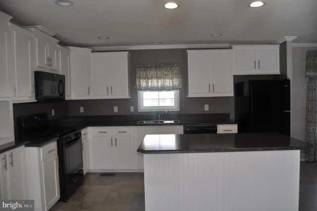 a kitchen with a sink a microwave a refrigerator and cabinets