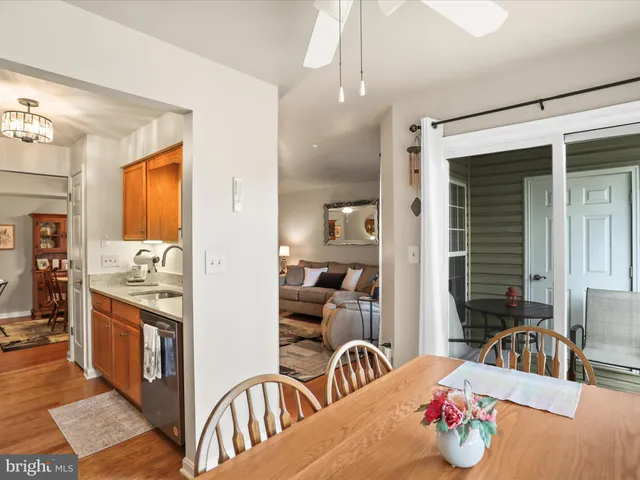 a kitchen with stainless steel appliances kitchen island granite countertop a stove a sink a dining table and chairs with wooden floor