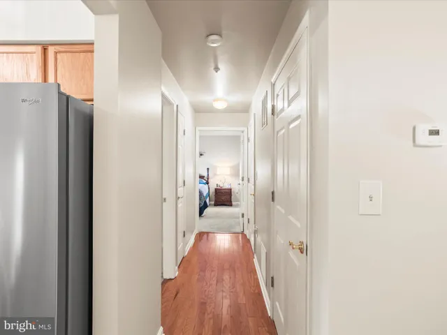 a view of hallway with livingroom and wooden floor
