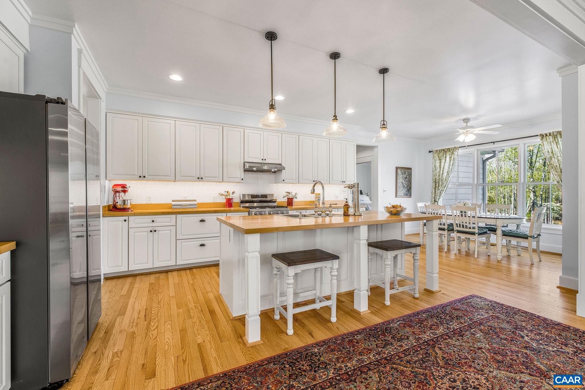 4764 Advance Mills Road Earlysville, VA 22936 - Photo 32 of 72 a kitchen with stainless steel appliances granite countertop a stove a refrigerator a oven a sink a dining table and chairs with white cabinets