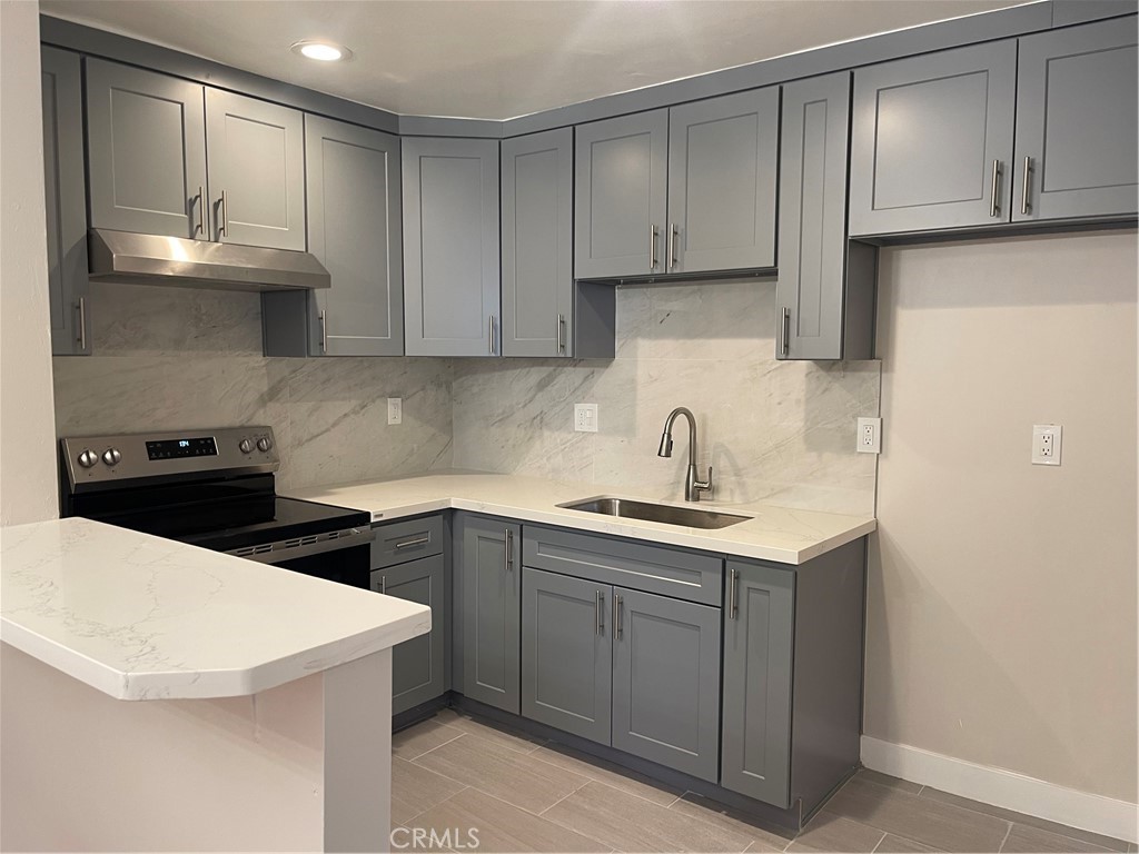 17226 Virginia Avenue, Unit D Bellflower, CA 90706 - Photo 4 of 8 a kitchen with a sink a stove and cabinets