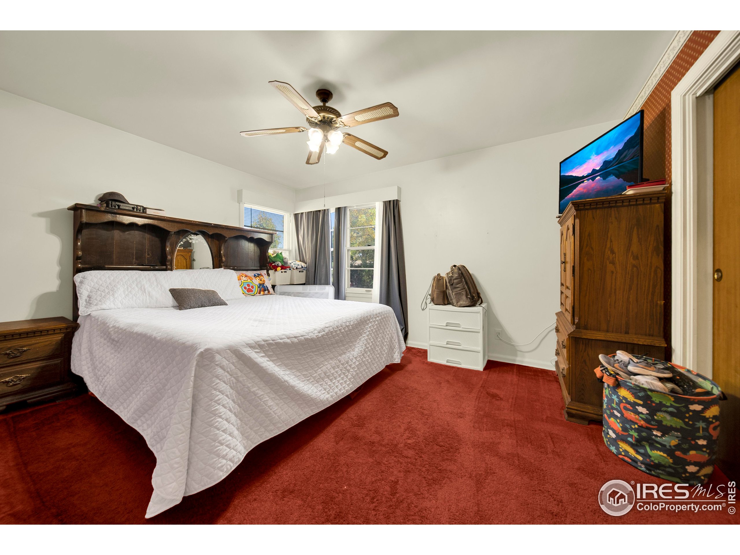 724 Carson Street Brush, CO 80723 - Photo 14 of 29 a bedroom with a bed and a chandelier