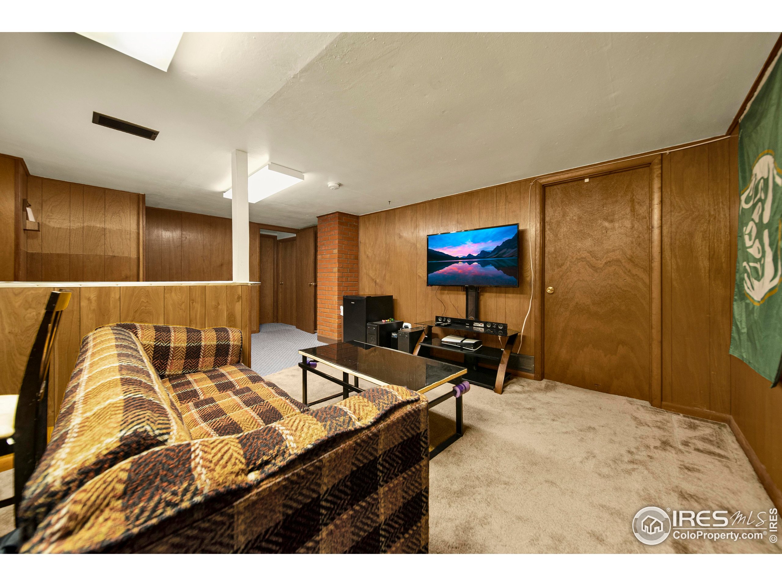 724 Carson Street Brush, CO 80723 - Photo 21 of 29 a living room with a couch and a flat screen tv